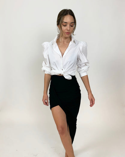 Tied white cotton puff sleeve button down and black maxi skirt on model with hair in low bun