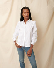 Black, fuller bust model pairing white cotton puff sleeve button down with blue jeans