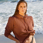 Vintage tobacco cotton fleece long sleeve sweatshirt on brunette model at the beach in black bikini bottoms