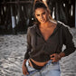 Grey cotton fleece puff sleeve zip up sweatshirt half zipped on white model wearing unzipped blue jeans and ponytail on beach