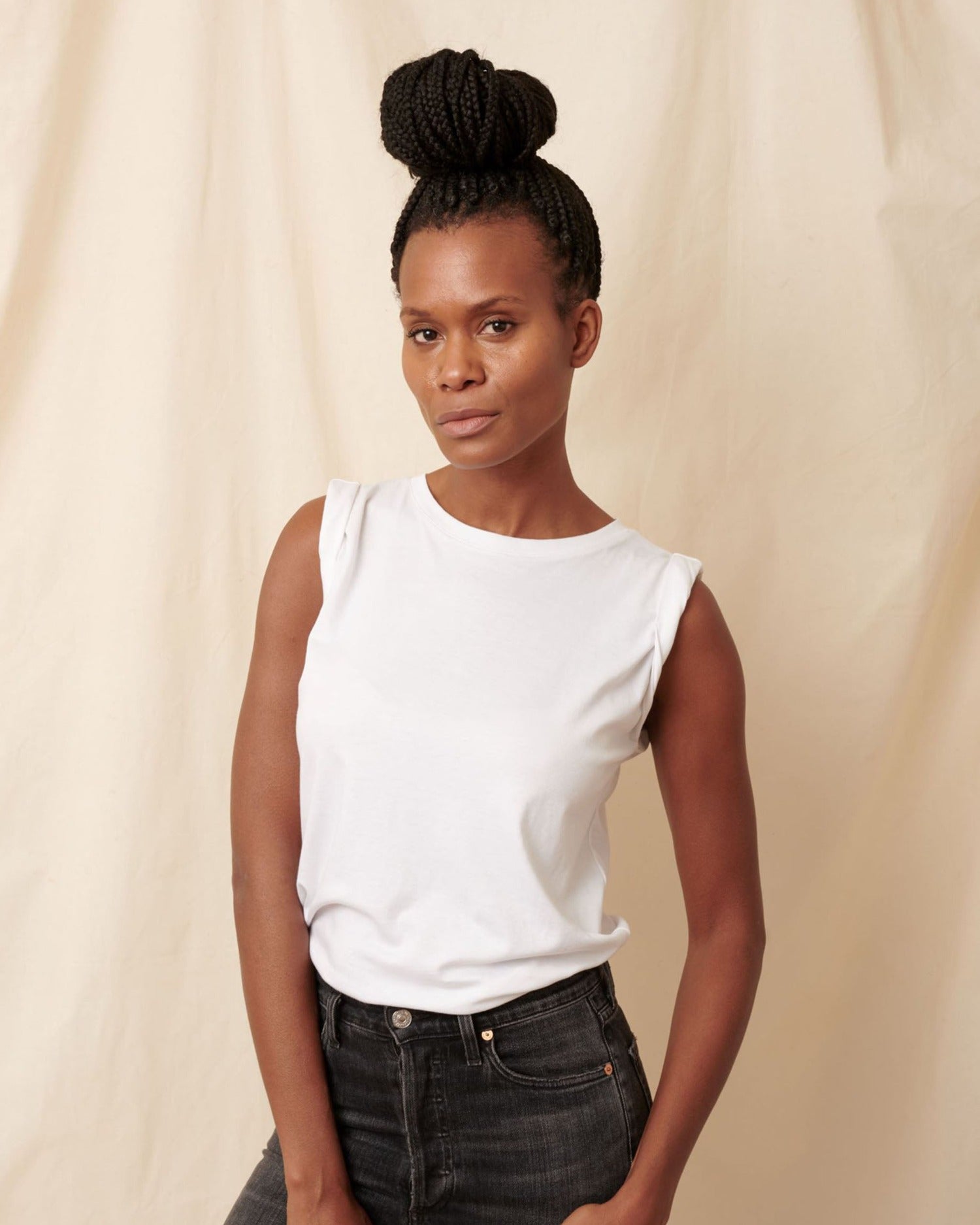Thin, large chested black model wearing white pima cotton muscle tee