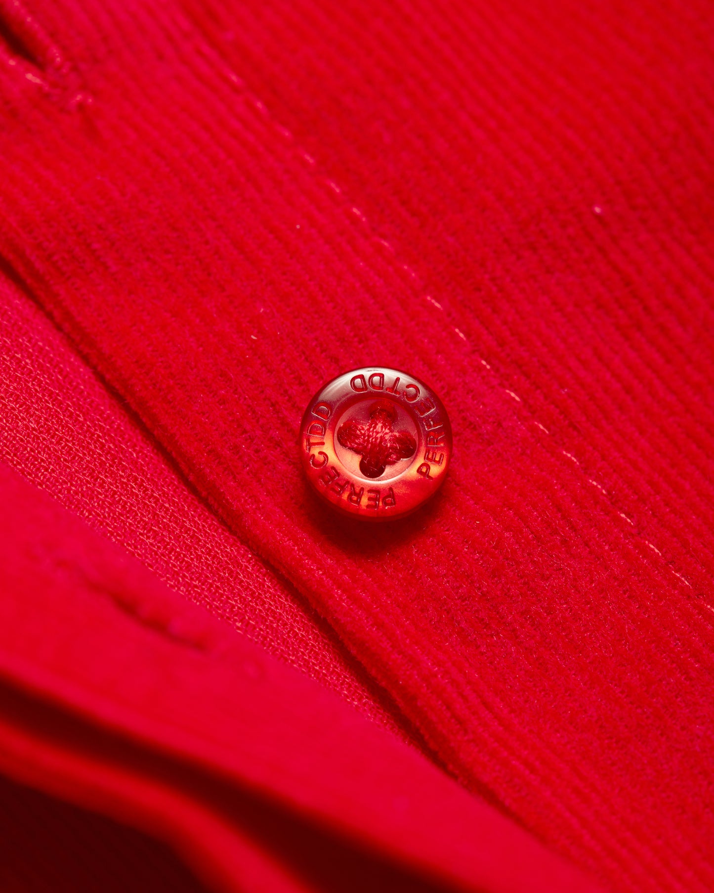 Branded logo button detail on red Japanese corduroy puff sleeve button down