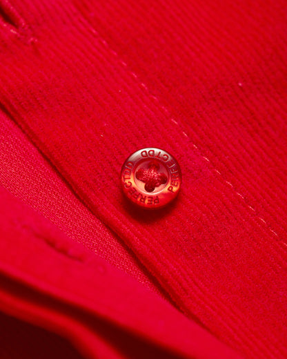 Branded logo button detail on red Japanese corduroy puff sleeve button down