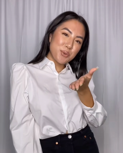 White cotton puff sleeve button down on fuller bust influencer/model blowing a kiss