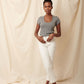 Heather grey supima cotton scoopneck tulip sleeve tee on black model wearing white jeans with hands on pockets