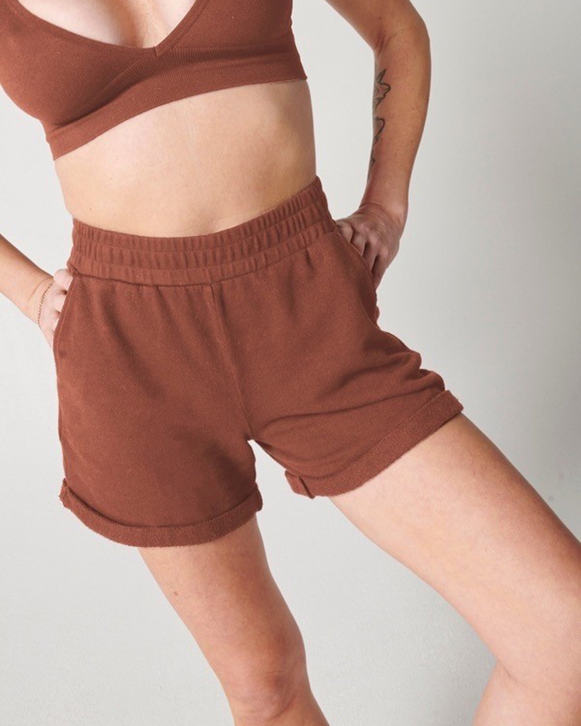 Vintage tobacco organic cotton sweat shorts and vintage tobacco bra on woman's body with hands on hips
