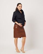 Black cotton long sleeve classic button down on pregnant model holding belly wearing brown leather skirt and clear sandals