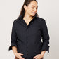 Close-up of Black cotton long sleeve classic button down on smiling pregnant model holding belly and looking to side