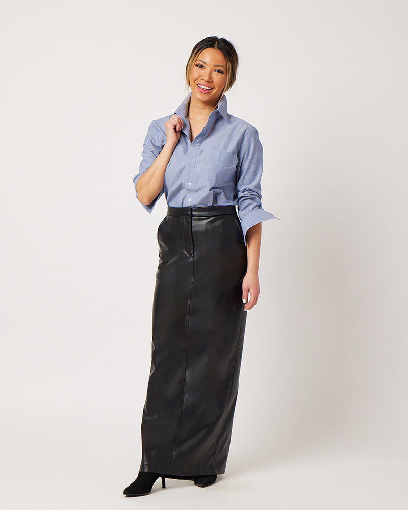 Chambray cotton long sleeve classic button down tucked into black leather skirt on smiling asian model holding collar