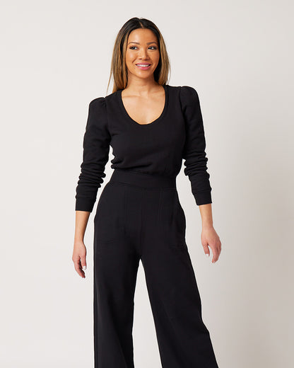 Black cotton fleece jumpsuit on smiling, asian fuller busted model looking to sidee