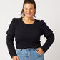 Black organic cotton double sleeve crewneck sweatshirt on smiling model wearing blue jeans, gold jewelry and ponytail