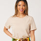 Close-up of latte cotton rolled sleeve tshirt tucked into colorful sequin skirt on smiling asian model