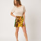 Latte cotton rolled sleeve tshirt tucked into colorful sequin skirt on smiling asian model looking to side