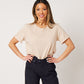 Latte cotton rolled sleeve tshirt tucked into navy cargo pants on smiling asian model wearing chunky gold necklace