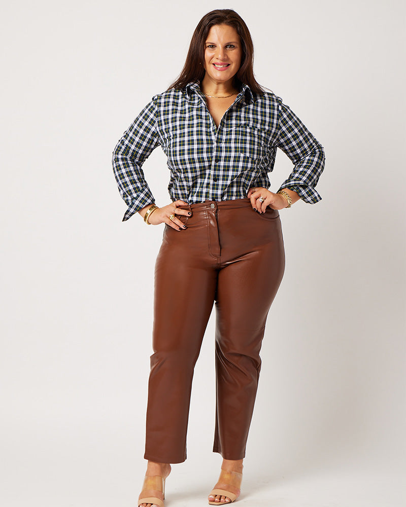Plaid cotton long sleeve classic button down tucked into brown leather pants on smiling white model