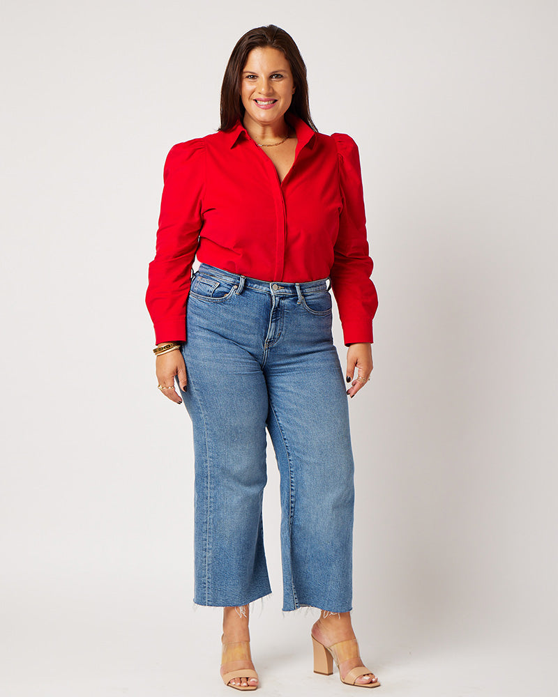 Red Japanese corduroy puff sleeve button down on brunette model wearing blue jeans and nude heels
