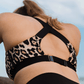 Back detail of leopard recycled polyester sports bra with magnetic closure and adjustable slider
