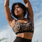 Leopard recycled polyester sports bra on fuller bust model with hands in air