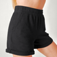 Side profile of woman wearing black organic cotton sweat shorts