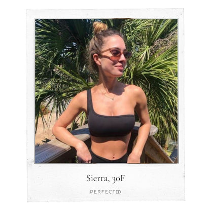 Polaroid picture of thin, large chested, white woman in a black bikini and sunglasses