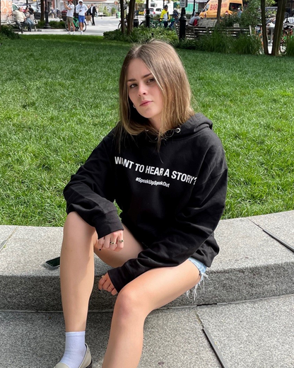 Black unisex long sleeve sweatshirt on model sitting on park steps